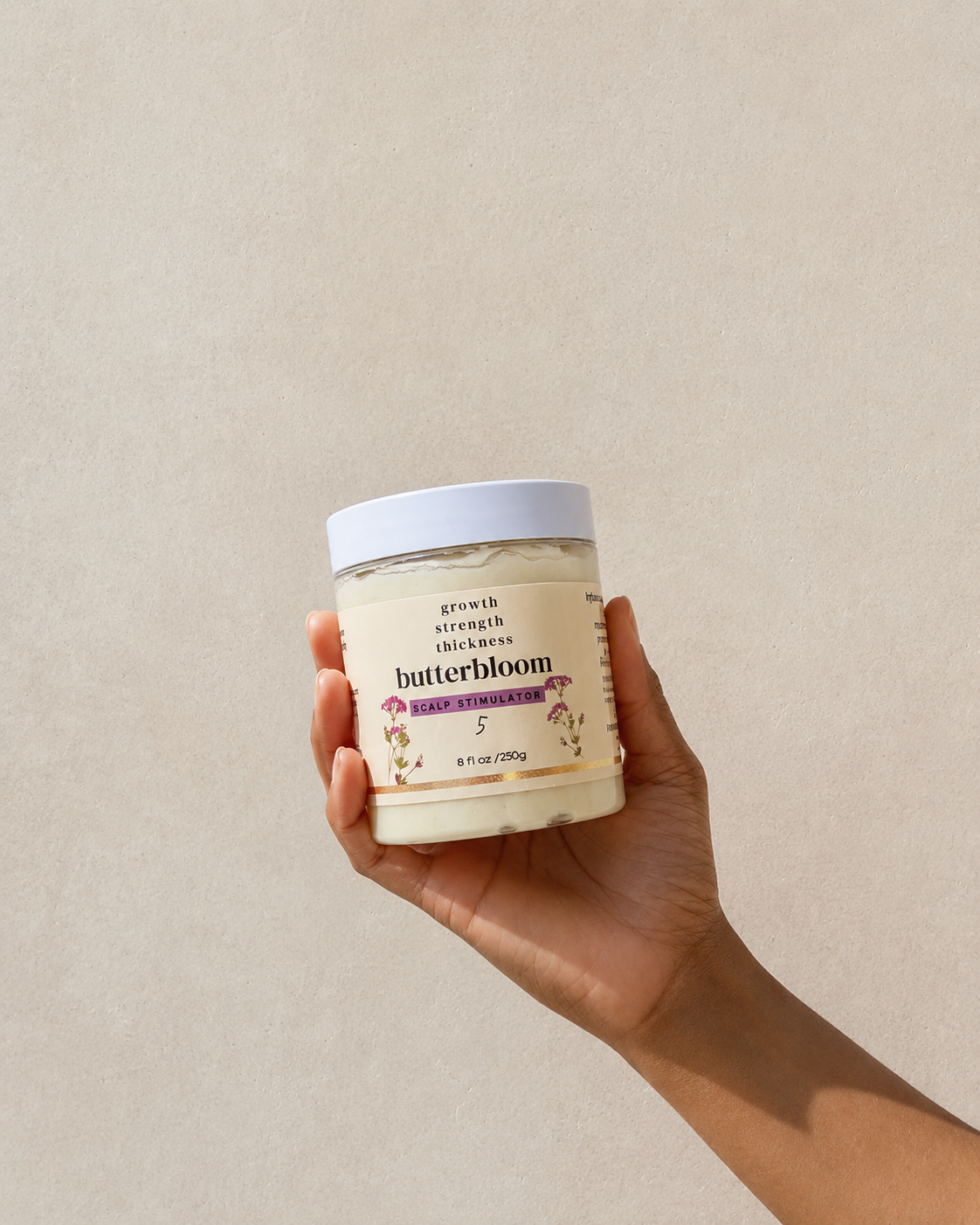 Butterbloom hair growth scalp stimulator balm jar with applicator brush, designed to promote healthy hair and scalp.