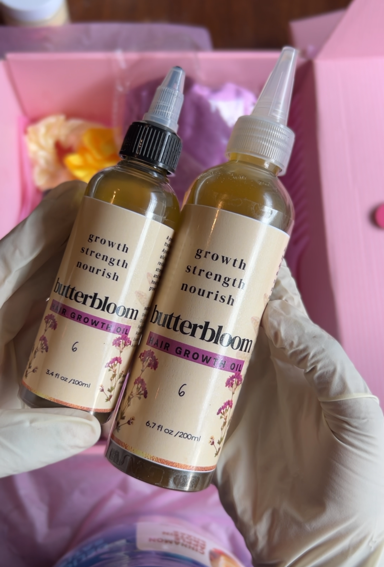 Butterbloom hair growth oil bottle surrounded by 21 fresh herbs, showcasing its natural ingredients for healthy hair.